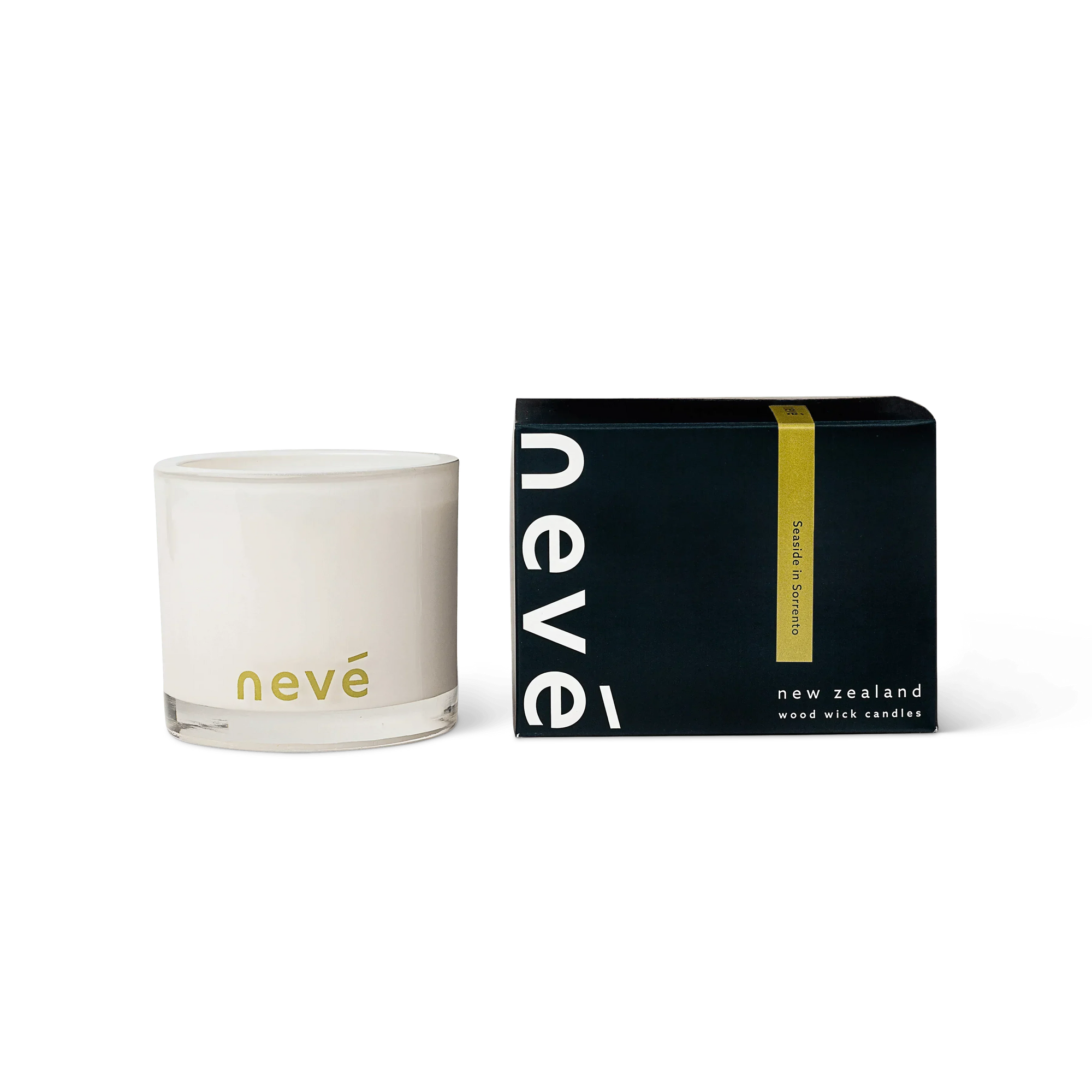 Neve scented white candle with wooden wick surrounded by green leaves and fresh lemon on white surface